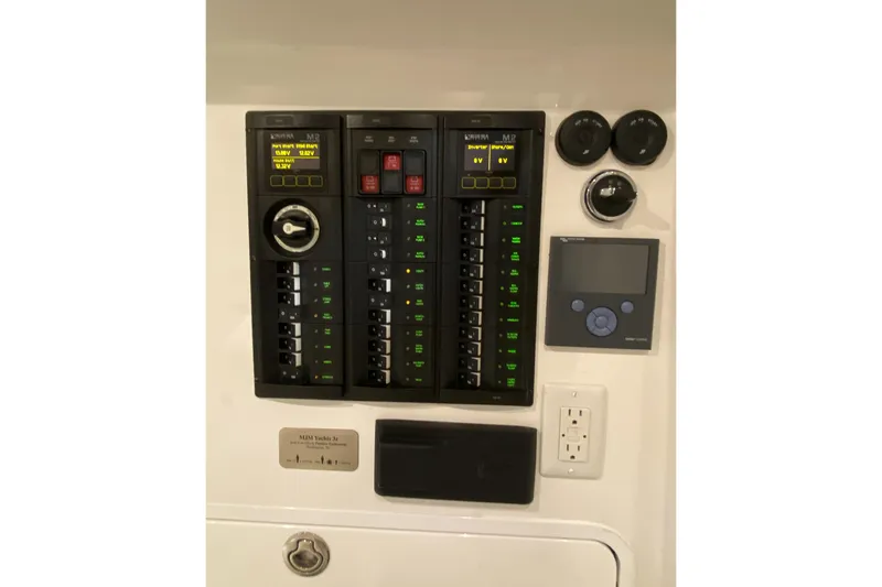 Slide: The Image of Electrical control panel on a 2022 MJM 3 boat, featuring switches and displays. - 53