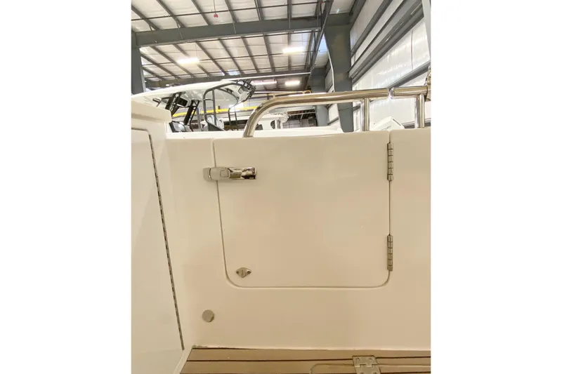 Slide: The Image of 2022 MJM 3 boat interior with white door and stainless steel railing in a warehouse. - 72
