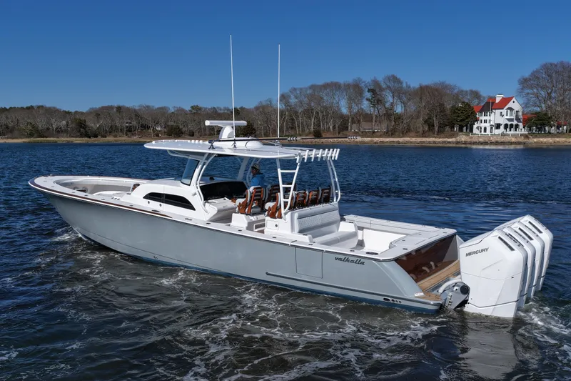 Slide: The Image of 2026 Valhalla Boatworks V-46 cruising on a scenic lake with a picturesque house in the background. - 11