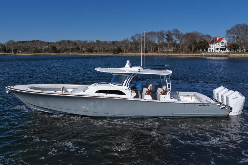 Slide: The Image of 2026 Valhalla Boatworks V-46 cruising on a serene lake with a scenic shoreline backdrop. - 12