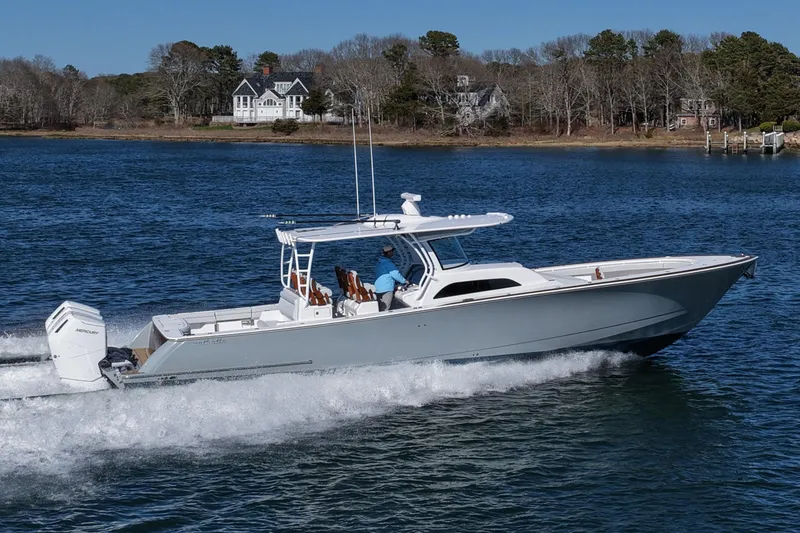 The Image of 2026 Valhalla Boatworks V-46 cruising on a serene lake with a scenic backdrop. - 2