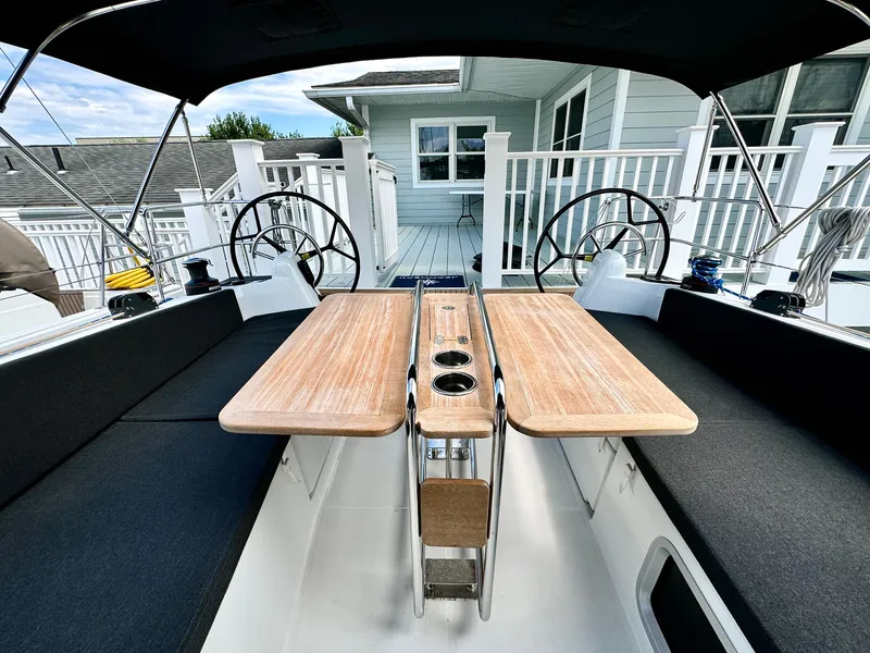 Slide: The Image of 2023 Jeanneau Sun Odyssey 380 cockpit with dual steering wheels and wooden table. - 17