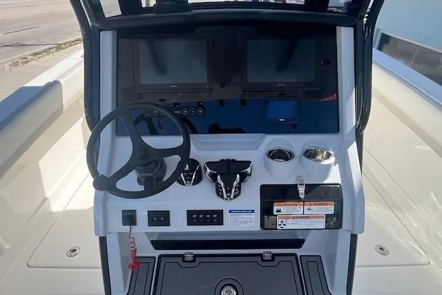 Slide: The Image of 2026 World Cat 280 CC-X boat dashboard with steering wheel and dual screens. - 4