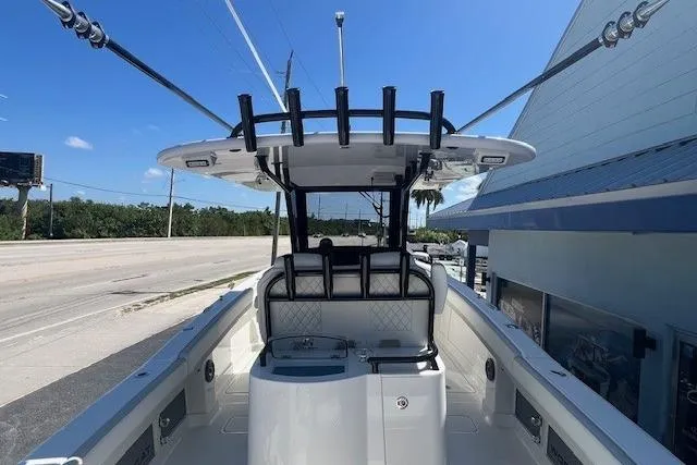 Slide: The Image of 2026 World Cat 280 CC-X boat interior with seating and rod holders under a clear blue sky. - 7