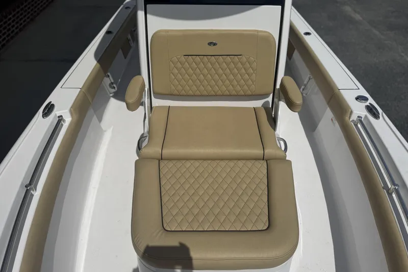 Slide: The Image of 2025 Sportsman Masters 247OE Bay Boat with tan cushioned seating and diamond stitching. - 12