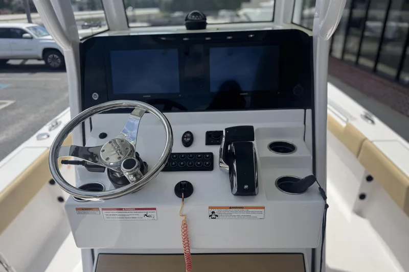 Slide: The Image of 2025 Sportsman Masters 247OE Bay Boat helm with steering wheel and controls. - 17