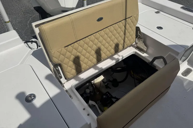 Slide: The Image of Open storage compartment on 2025 Sportsman Masters 247OE Bay Boat with tan cushioned seat. - 19