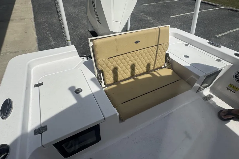 Slide: The Image of 2025 Sportsman Masters 247OE Bay Boat with tan cushioned seating and storage compartments. - 20