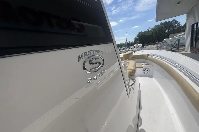Slide: The Image of 2025 Sportsman Masters 247OE Bay Boat, sleek design, beige seating, outdoor display. - 24