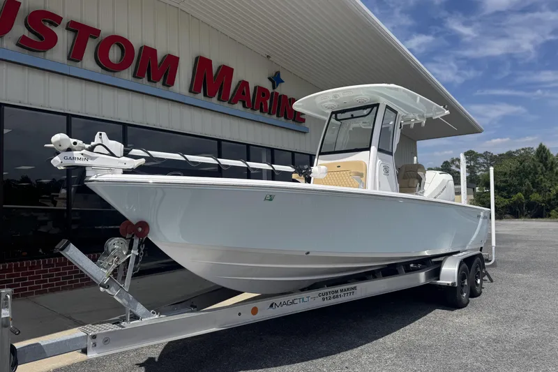 Slide: The Image of 2025 Sportsman Masters 247OE Bay Boat on trailer outside Custom Marine dealership. - 7