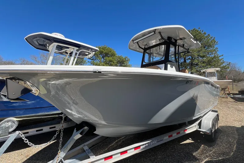 The Image of 2021 Sea Pro 239 Center Console boat on trailer under clear blue sky. - 0