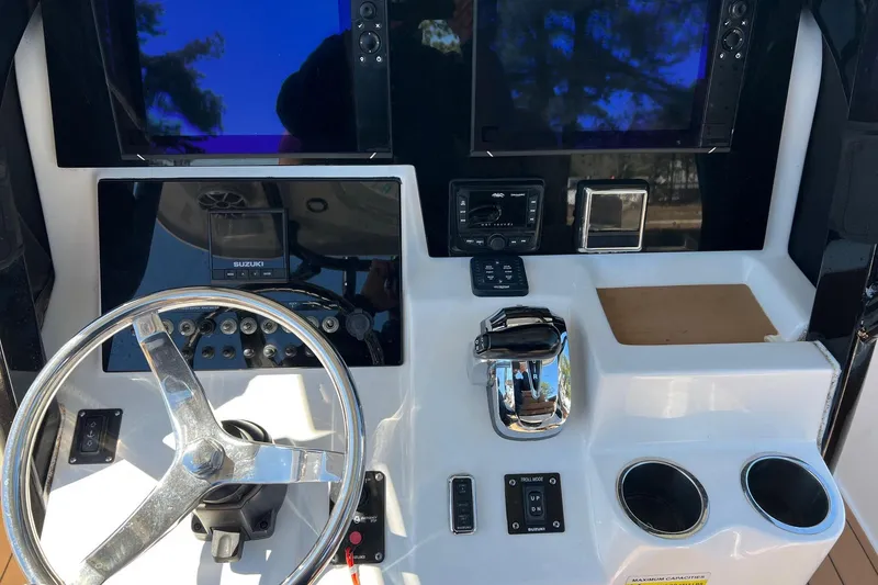 Slide: The Image of 2021 Sea Pro 239 Center Console helm with steering wheel, controls, and dual displays. - 10