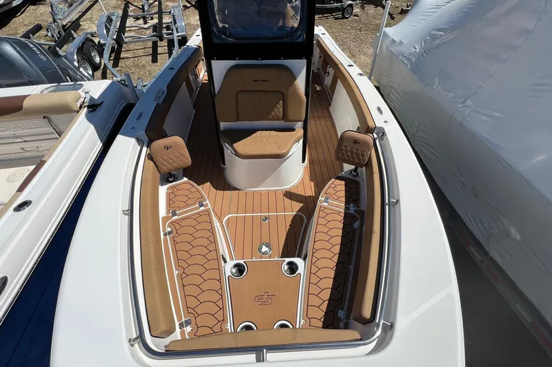 Slide: The Image of 2021 Sea Pro 239 Center Console boat interior with tan seating and wood-style flooring. - 11