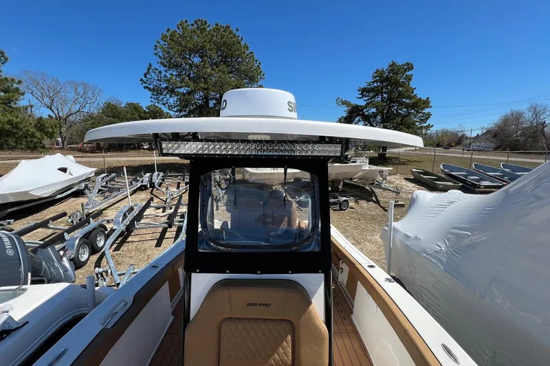 Slide: The Image of 2021 Sea Pro 239 Center Console boat in outdoor storage, surrounded by trailers and trees. - 12