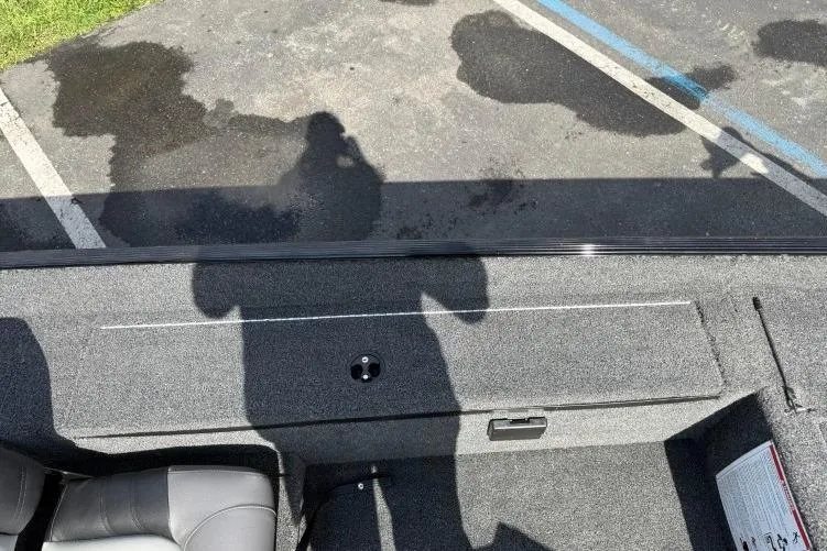 Slide: The Image of 2026 Crestliner 1700 Storm boat interior with gray carpet and seating, parked on asphalt. - 10