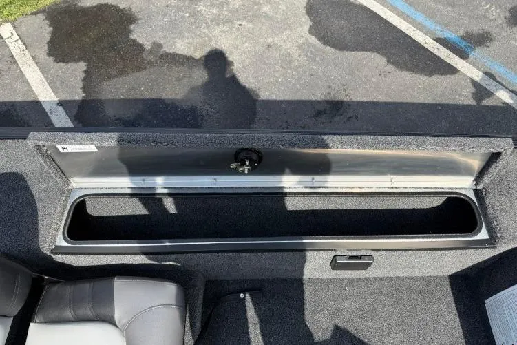 Slide: The Image of Open storage compartment in 2026 Crestliner 1700 Storm boat, with shadow reflections. - 11