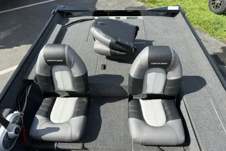 Slide: The Image of 2026 Crestliner 1700 Storm boat interior with two gray and black seats on a carpeted deck. - 8