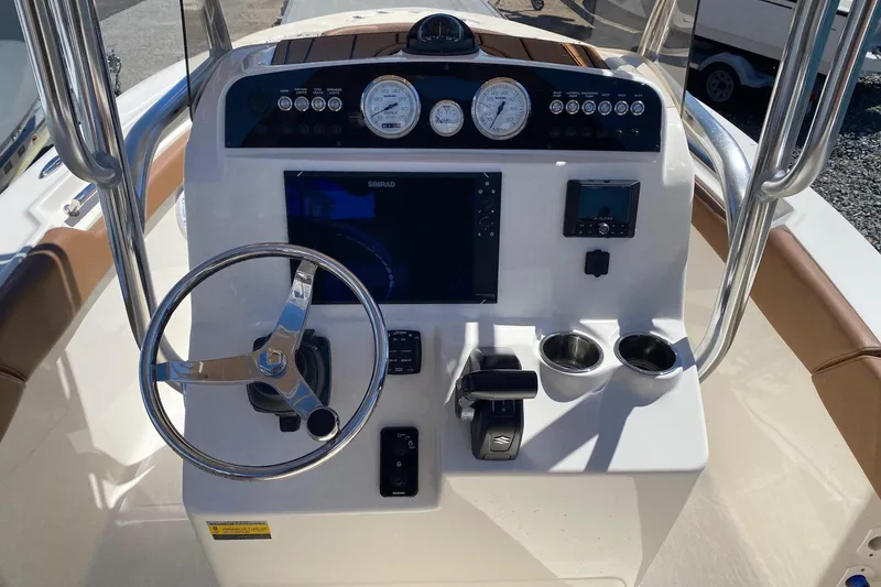Slide: The Image of 2023 Pioneer 202 Sportfish boat dashboard with steering wheel, gauges, and controls. - 10