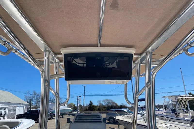 Slide: The Image of 2023 Pioneer 202 Sportfish boat with T-top and electronics display, docked under clear blue sky. - 11