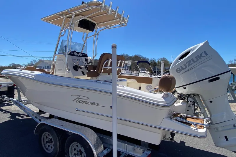 Slide: The Image of 2023 Pioneer 202 Sportfish boat with Suzuki engine on trailer, under clear blue sky. - 3