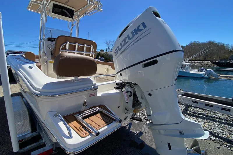 Slide: The Image of 2023 Pioneer 202 Sportfish boat with Suzuki outboard motor, docked by the water. - 5