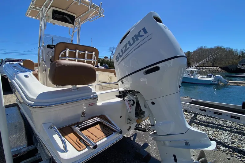 Slide: The Image of 2023 Pioneer 202 Sportfish boat with Suzuki outboard motor by the water. - 9