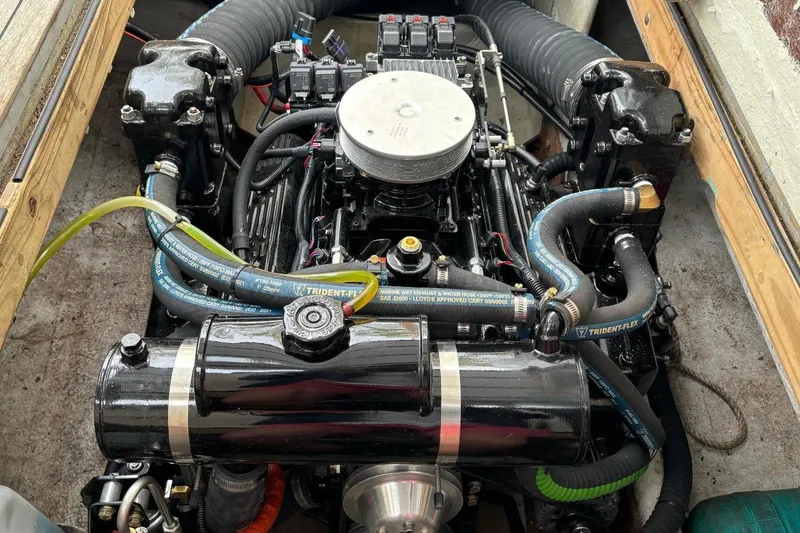 Slide: The Image of Engine of a 1996 Webbers Cove 26 boat, featuring hoses and mechanical components. - 10