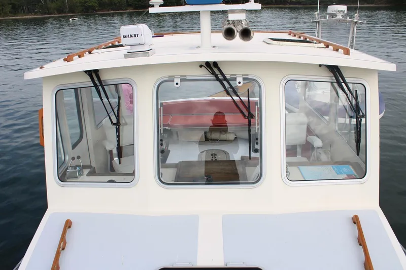 Slide: The Image of 1996 Webbers Cove 26 boat with cabin windows, docked on calm water. - 4