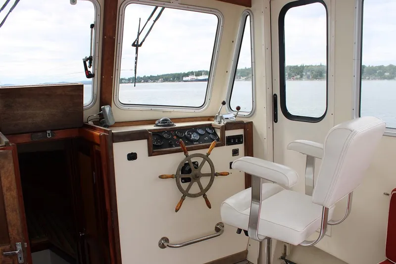 Slide: The Image of Interior of a 1996 Webbers Cove 26 boat, featuring helm and captain's chair. - 5