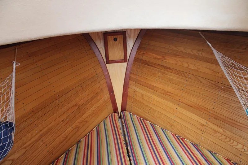 Slide: The Image of Interior of a 1996 Webbers Cove 26 boat with wooden paneling and striped cushions. - 8