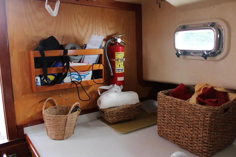 Slide: The Image of Interior of 1996 Webbers Cove 26 boat with storage baskets and a fire extinguisher. - 9