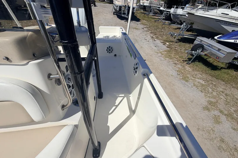 Slide: The Image of 2021 Bulls Bay 2200 boat interior with seating and railing, parked on a gravel lot. - 10