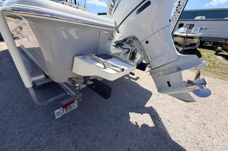 Slide: The Image of 2021 Bulls Bay 2200 boat with outboard motor and swim platform, parked on gravel. - 17