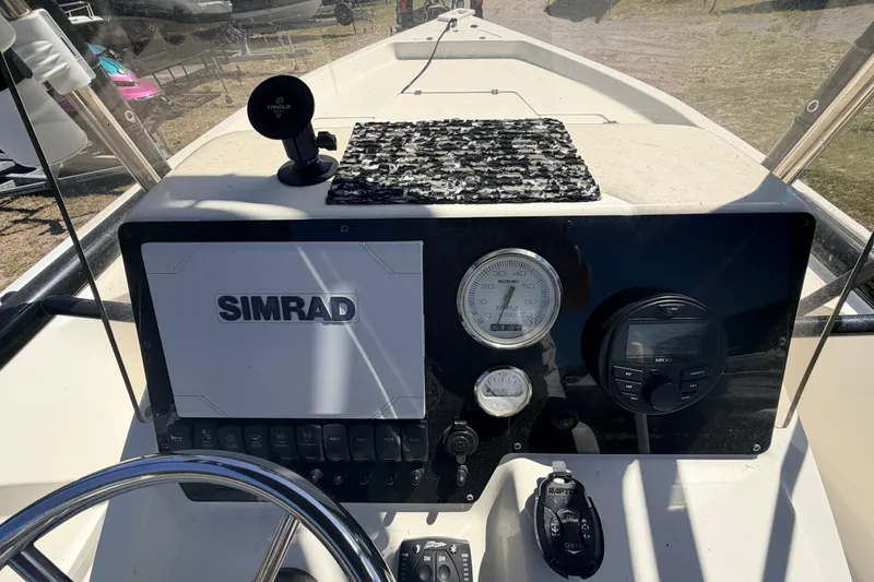 Slide: The Image of 2021 Bulls Bay 2200 boat dashboard with Simrad display and controls. - 6