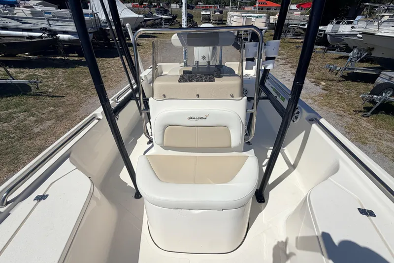 Slide: The Image of 2021 Bulls Bay 2200 boat interior with seating and console, parked outdoors. - 8