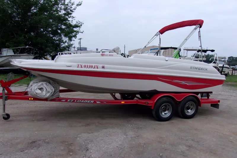 The Image of 2004 Stardeck 201 boat on red trailer, parked outdoors. - 1