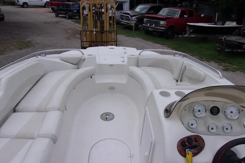 Slide: The Image of 2004 Stardeck 201 boat interior with white seating and dashboard, parked outdoors. - 4