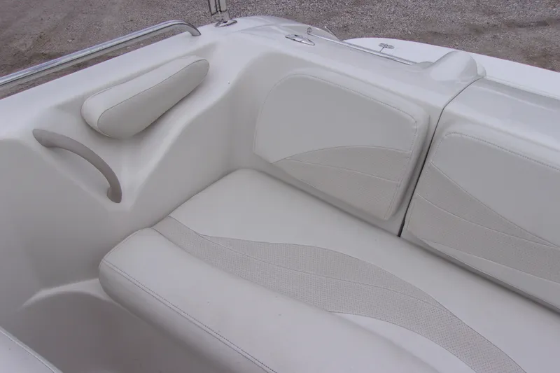 Slide: The Image of White seating area on a 2004 Stardeck 201 boat, featuring cushioned seats and armrest. - 8