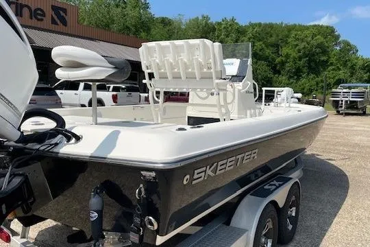 Slide: The Image of 2020 Skeeter SX240 boat on trailer, parked outdoors near dealership. - 2