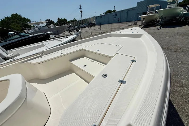 Slide: The Image of 2026 Bulls Bay 2400 boat, spacious deck, parked in a marina under clear skies. - 3