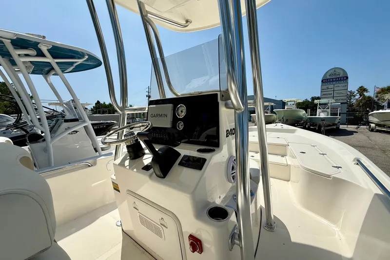 Slide: The Image of 2026 Bulls Bay 2400 boat interior with Garmin navigation system, parked at a dealership. - 4