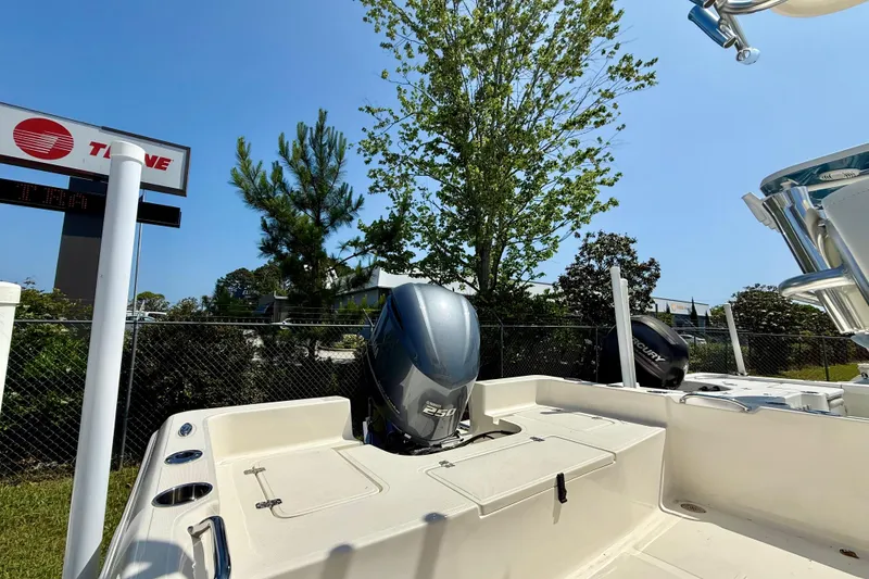 Slide: The Image of 2026 Bulls Bay 2400 boat with powerful outboard motor, parked outdoors under clear blue sky. - 5