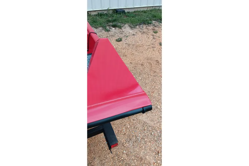 Slide: The Image of Red Tracker Pro Team 175 boat detail, 2026 model, on gravel surface. - 10