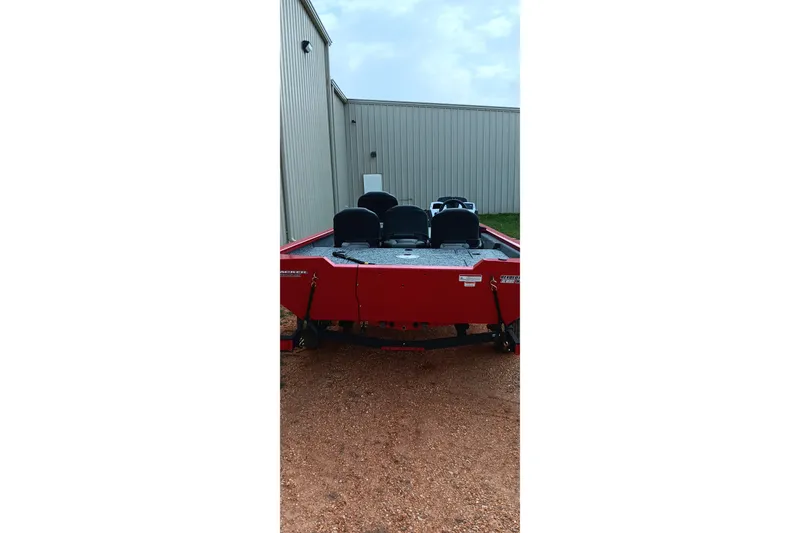 Slide: The Image of Red 2026 Tracker Pro Team 175 boat parked near a metal building. - 13