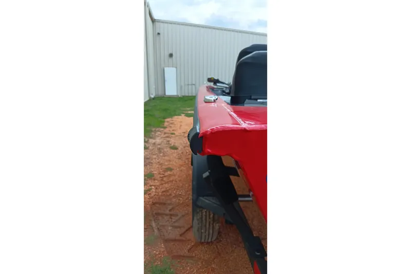 Slide: The Image of Red Tracker Pro Team 175 boat, 2026 model, parked beside a building. - 3