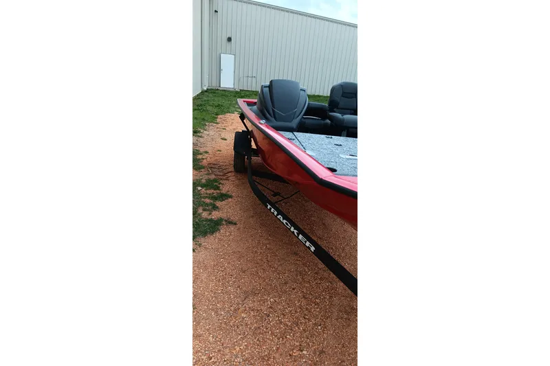 Slide: The Image of 2026 Tracker Pro Team 175 boat on trailer, parked on gravel near a building. - 5