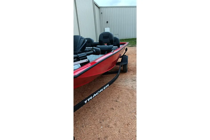 Slide: The Image of Red 2026 Tracker Pro Team 175 boat on trailer, parked near metal building. - 6