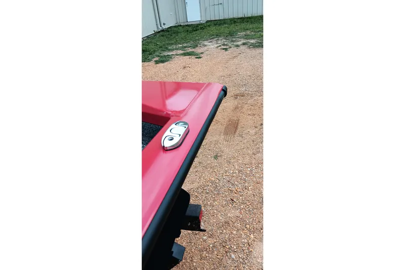 Slide: The Image of Red Tracker Pro Team 175 boat detail, 2026 model, parked on gravel near a building. - 8