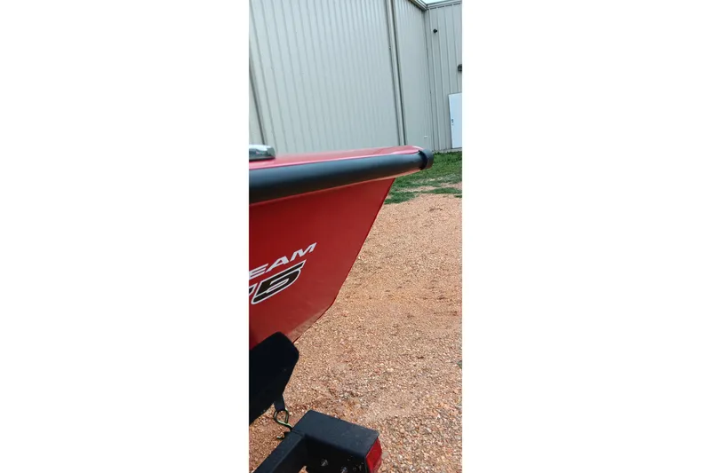 Slide: The Image of Red 2026 Tracker Pro Team 175 boat parked on gravel near a metal building. - 9