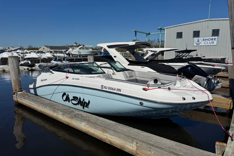 The Image of 2019 Hurricane SunDeck 2486 OB boat docked at marina, labeled "Oh Ship!" - 0